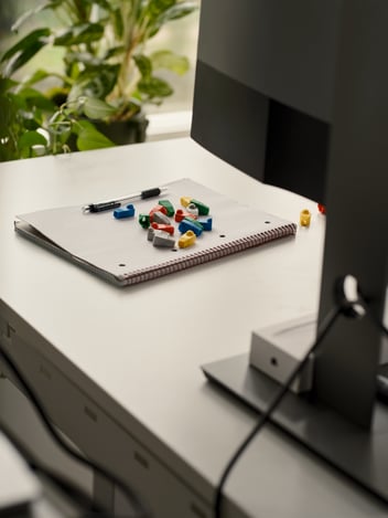 Computer screen, a notebook and some legos on a table