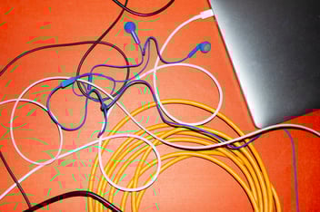 Laptop and cables on red table