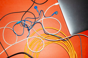 Laptop and cables on red table