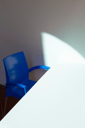 blue chair next to a white desk