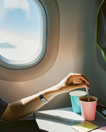 person on plane drinking coffee