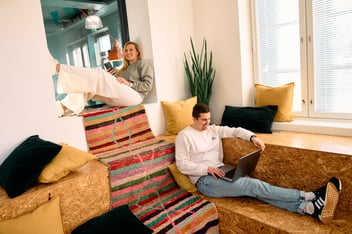 Two colleagues working casually in a bright office lounge