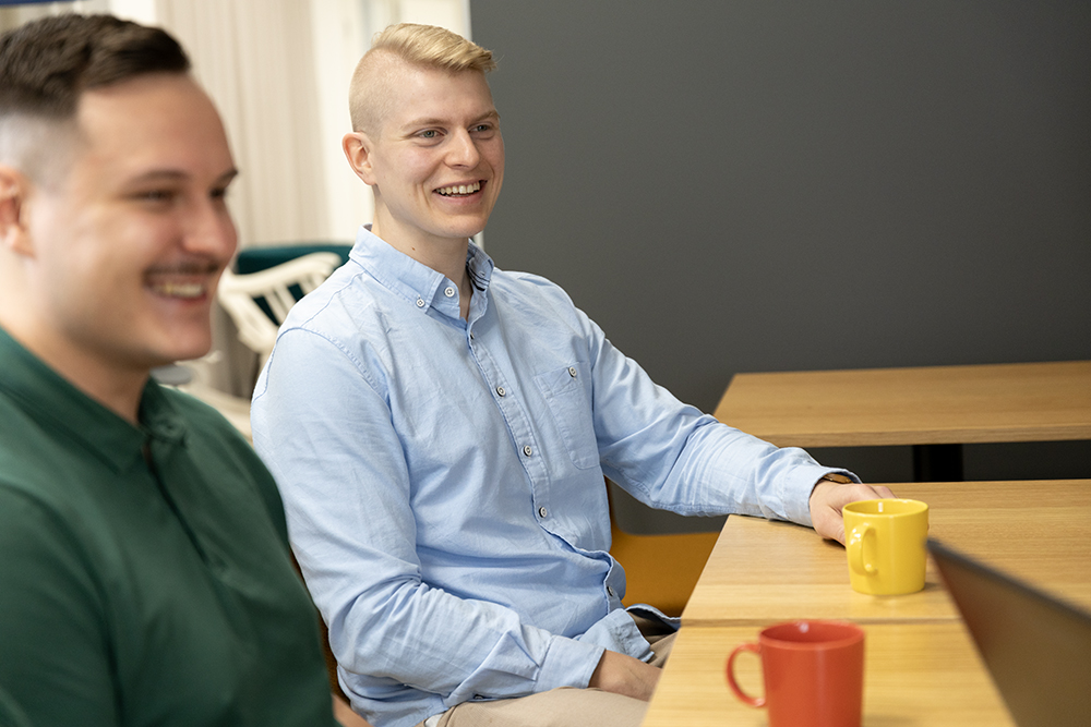 Two people drinking coffee in a meeting room