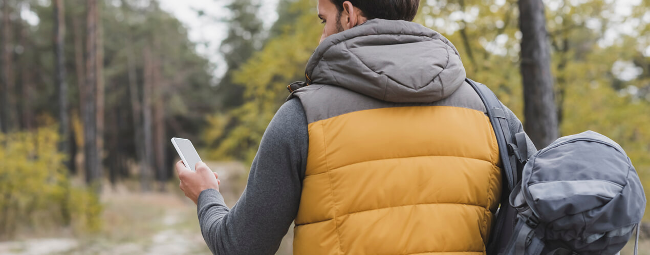 Person using a mobile app map in a forest