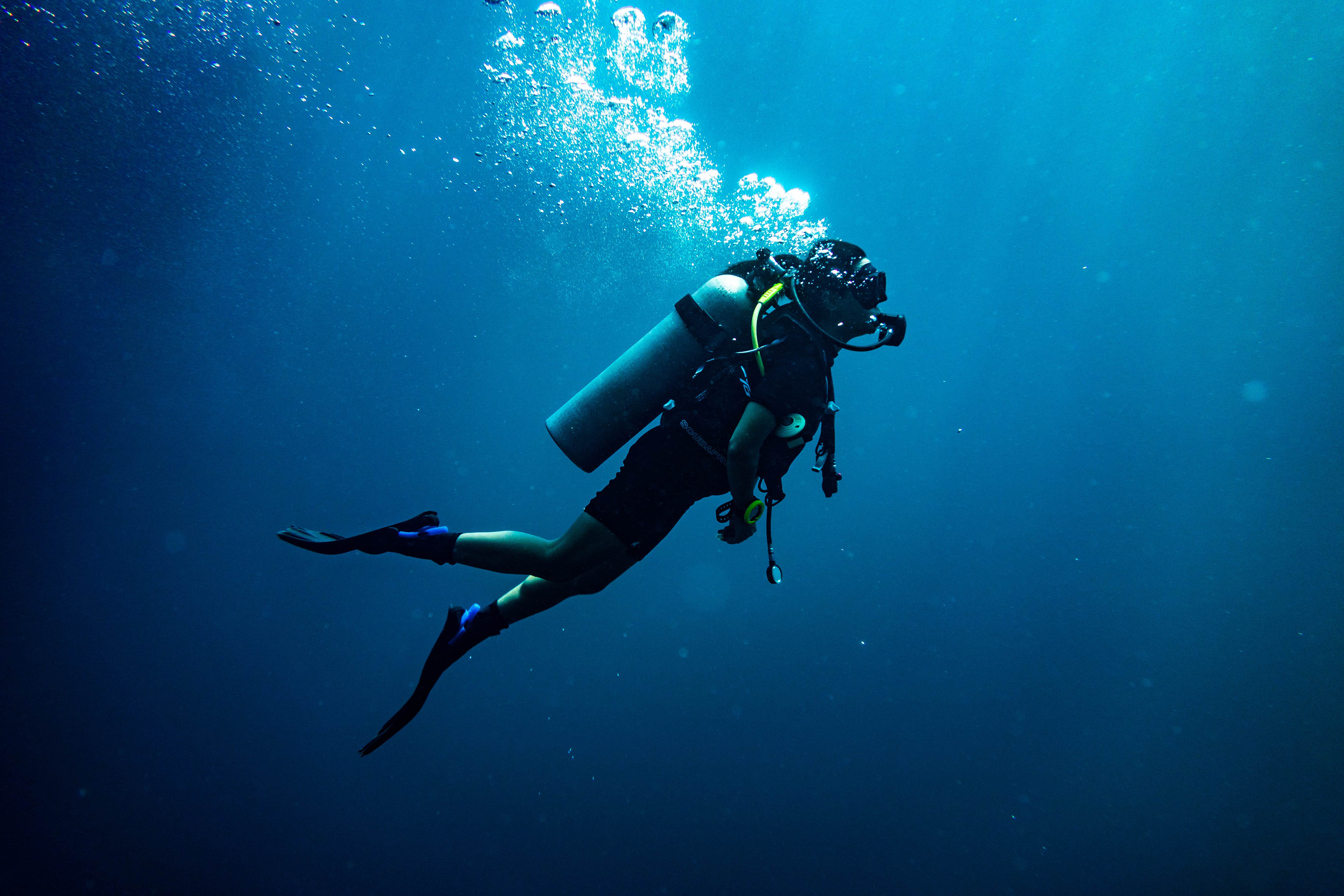 a scuba diver with their equipment on on a blue deep water